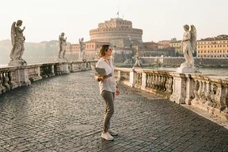 Femme consultant une carte sur le Ponte Sant'Angelo à Rome avec vue sur le Castel Sant'Angelo